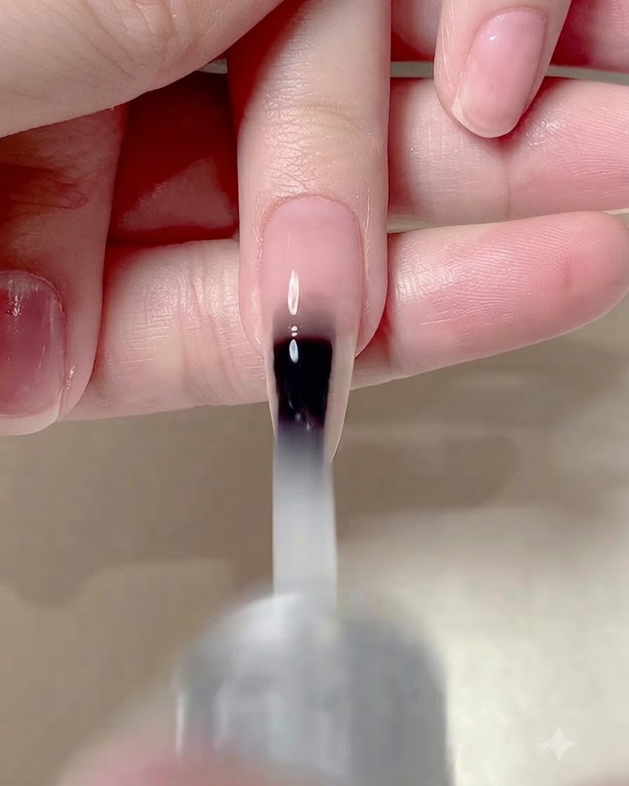 マニキュアを施した爪の表面全体にマットトップコートを塗布しているネイルブラシ。