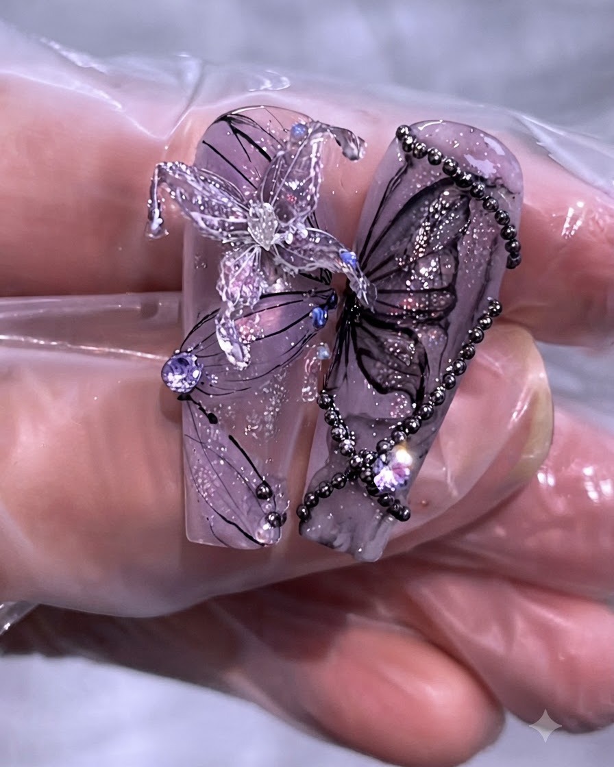 長いクリアネイルチップに施された、パープルバタフライとチェーンのネイルアート完成品のクローズアップ。
