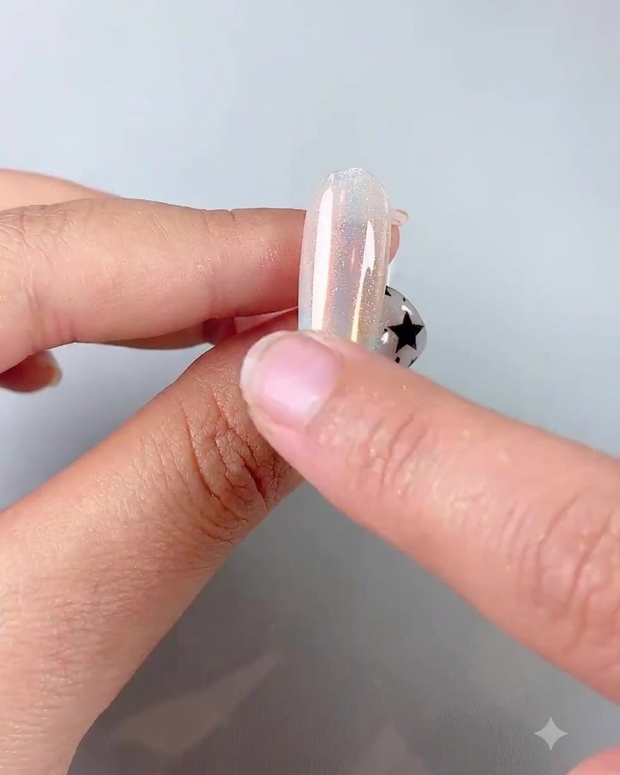 シリコンチップを使って、ツヤのあるネイルに偏光オーロラパウダーを擦り込んでいる様子。