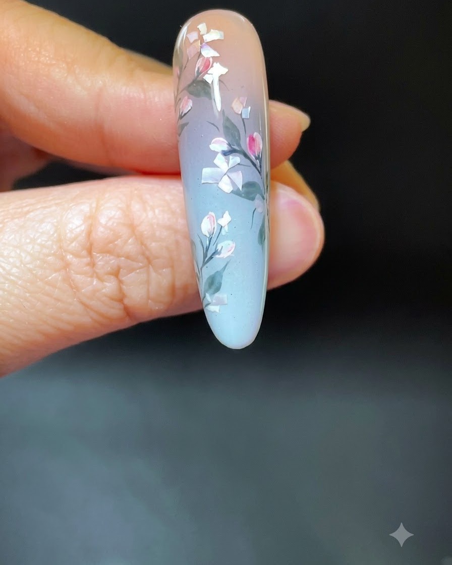 シェルとフラワーのネイルアートが完成した手を、白いUV/LED硬化ランプの中に入れている様子。