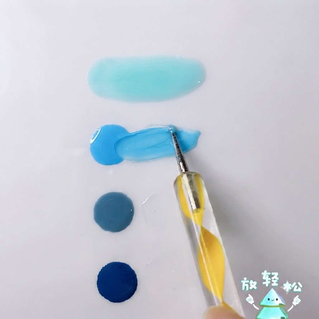 白いパレット表面で、明るいスカイブルージェルとクリアジェルをドットペンで混ぜ合わせている様子。