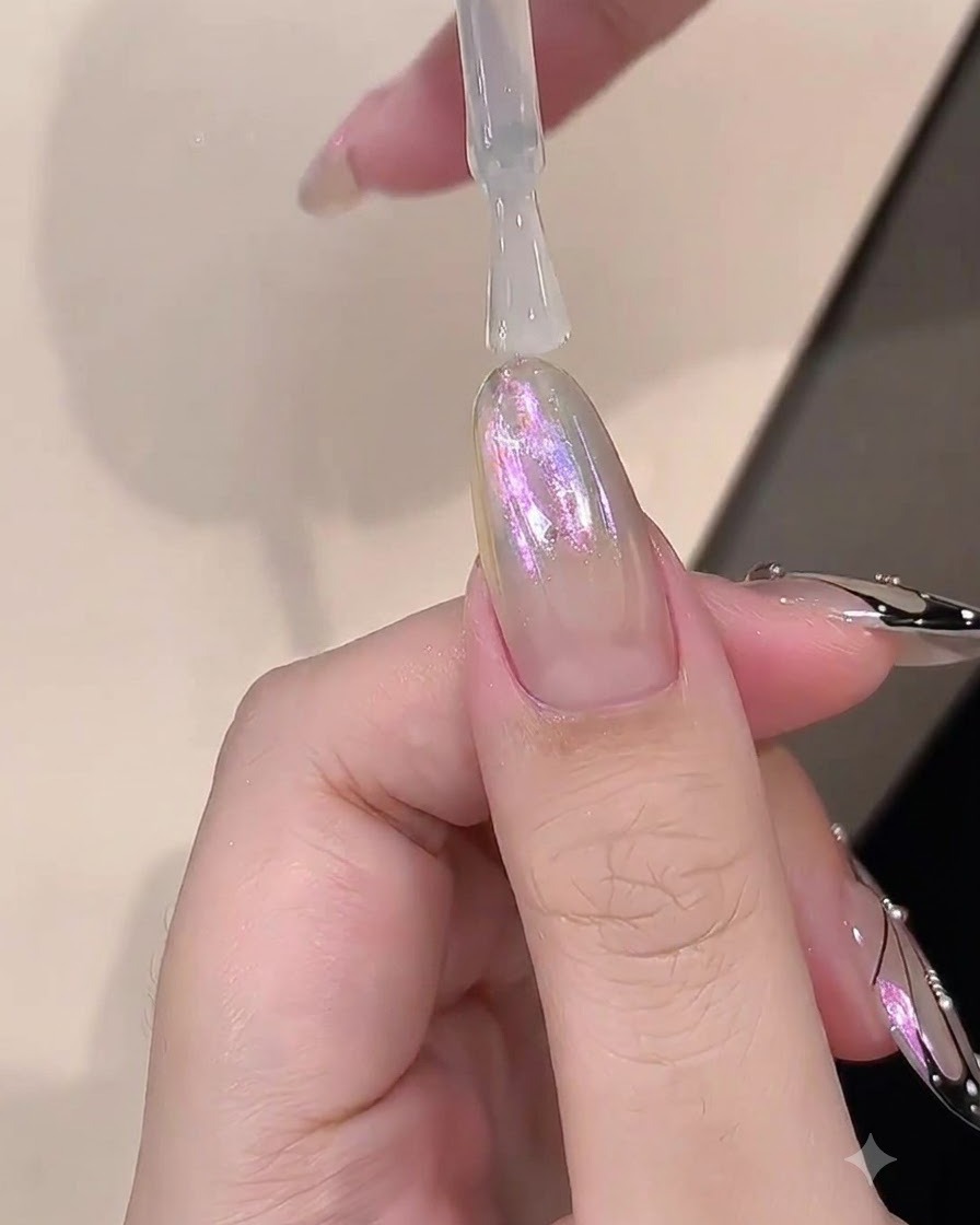 クロム仕上げの爪の上にビルダージェルの透明なレイヤーを塗布しているブラシ。